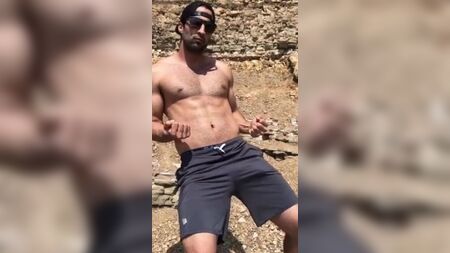 شاب مثير يرتدي شورتًا يظهر فيه انتفاخ كبير