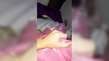 شخص يرتدي ملابس الجنس الآخر يرتدي فستانًا طويلًا من الساتان باللون الوردي لحفل التخرج